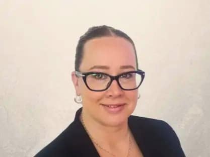 Professional woman smiling in office representing marketing manager driving property investment brand growth and investor engagement