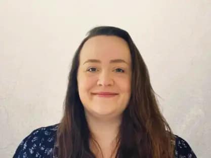 Professional woman smiling representing operations manager overseeing property investment processes and business efficiency