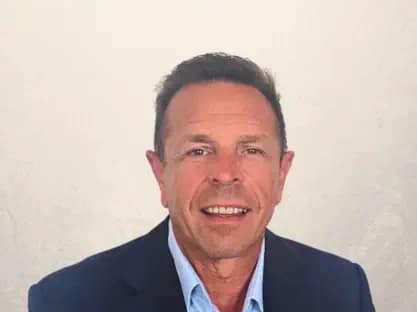 Professional man in suit smiling representing Paul Cox CEO property investment expert with extensive UK and European experience