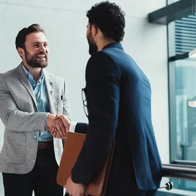 Two professionals shaking hands in office representing 365 Invest UK property investment experts building trusted client relationships